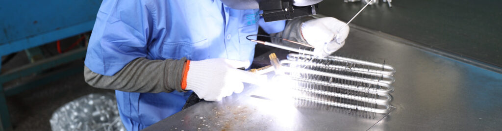 Worker brazing aluminum evaporator coil in Domi factory - Domi Refrigeration