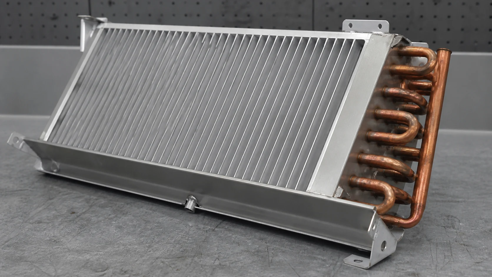 Macro view of wide-spaced fins and sloped coil slabs designed for natural convection and drainage