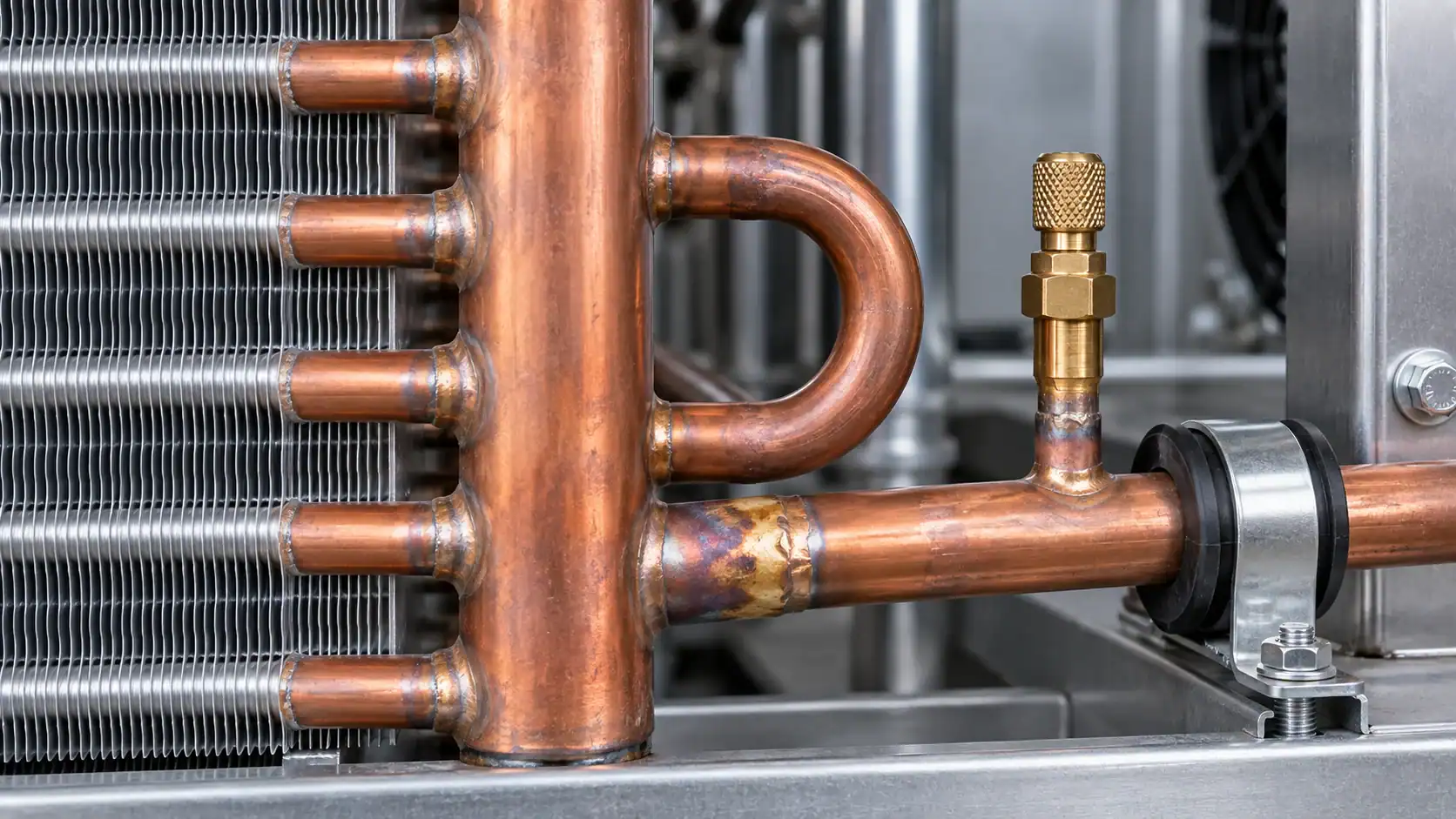 Close-up of copper refrigeration pipes and components in an industrial cooling system.